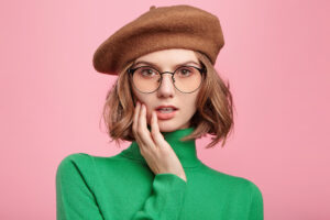 Pretty female students wears retro clothes listens attentively professor`s lecture, has serious expression, tries to understand everything. Cute woman in beret and turteneck sweater isolated on pink 20 برند برتر عینک جهان - سفری به دنیای مد و دید